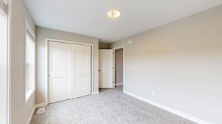 A room with white walls and carpeted floor with a ceiling light.