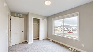 A room with a large window and a view of a building outside.