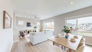 A modern living room with a dining table set for two.