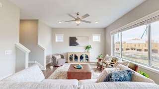 A living room with a couch, a coffee table, and a ceiling fan.