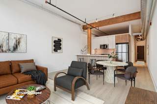 A living room with a brown couch and a white table.