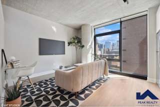 A living room with a couch, chair, and television.