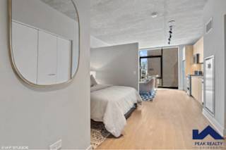 A bedroom with a round mirror on the wall.