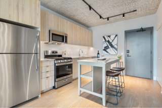 A kitchen with a refrigerator, oven, and microwave.