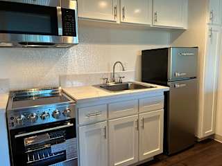 A modern kitchen with a stainless steel refrigerator, oven, and microwave.