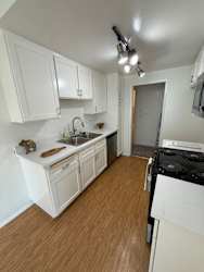 A kitchen with white cabinets and a black stove top oven.