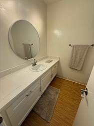 A bathroom with a sink, mirror, and towel rack.