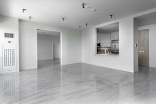 A white room with a marble floor and a kitchen in the background at Clayton on the Park Apartments, Missouri, 63105