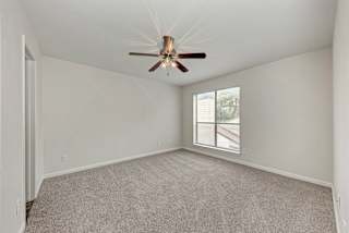 A room with a ceiling fan and a window.