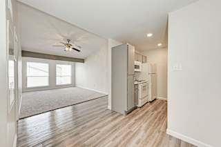 A kitchen with a refrigerator, microwave, and oven.