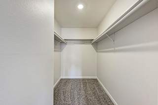 A long, narrow hallway with a carpeted floor and white walls.