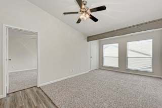 A room with a ceiling fan and a window with blinds.