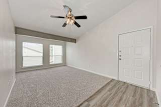 A room with a ceiling fan and a carpeted floor.