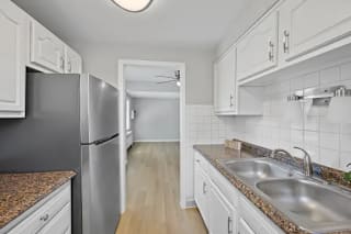 A kitchen with white cabinets and a granite countertop at Huntley Ridge Apartments, Kettering, Ohio