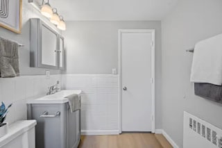 A bathroom with a white door and a white sink at Huntley Ridge Apartments, Kettering 45419