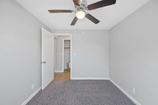 A room with a ceiling fan and carpeted floor at Huntley Ridge Apartments, Kettering