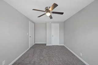 A room with a ceiling fan and carpeted floor at Huntley Ridge Apartments, Ohio