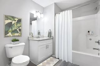 A white bathroom with a toilet, sink, and bathtub at Parkview of Lebanon Apartments, Lebanon, IN