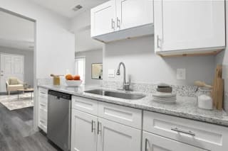 A modern kitchen with white cabinets and a marble countertop at Parkview of Lebanon Apartments, Indiana