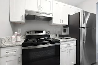 A black and white photo of a kitchen with a stove, oven, microwave, and refrigerator at Parkview of Lebanon Apartments, Lebanon