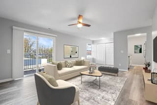 A living room with a white couch and a grey armchair at Parkview of Lebanon Apartments, Lebanon, Indiana
