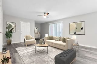 A living room with a grey rug and a grey ottoman at Parkview of Lebanon Apartments, Lebanon, IN