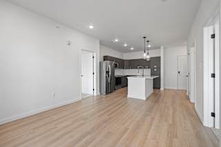 A spacious kitchen with a white island and wooden floors.