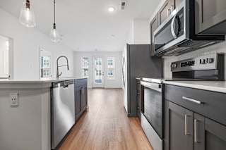 A modern kitchen with dark wood cabinets and stainless steel appliances.