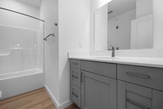 A bathroom with a white sink and a white tub.