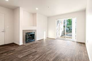 A spacious living room with a fireplace and hardwood floors.