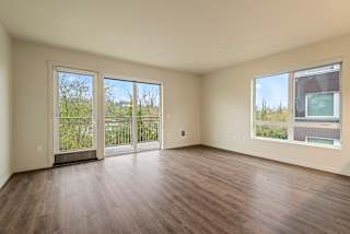 Empty room with sliding glass doors and wood flooring.