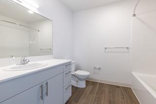 A white bathroom with a toilet, sink, and a bathtub.