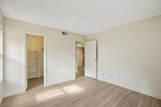 A room with a white door and a wooden floor.