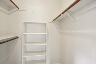 A white shelving unit in a room with white walls.
