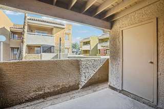 A view of a balcony with a door and a wall.