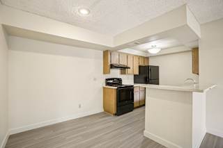 A kitchen area with a black fridge, stove, and microwave.