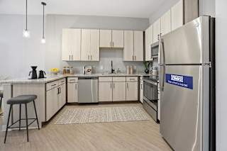 A kitchen with a stainless steel refrigerator that says "Sense of Style".