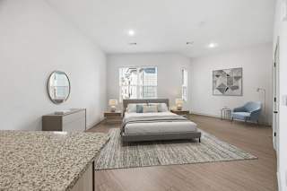 A bedroom with a large bed and a blue chair.