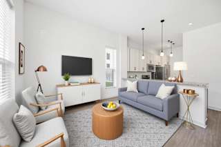 A modern living room with a grey sofa, a wooden coffee table, and a television.
