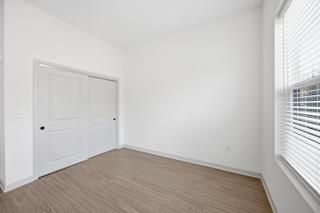 A room with a white door and a window with blinds.