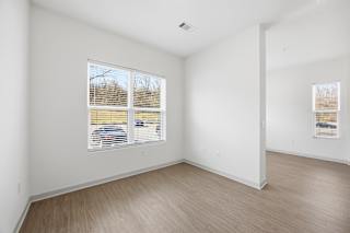 A room with a window and wooden flooring.