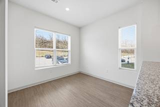 A room with two windows and a car parked outside.