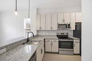 A kitchen with granite countertops and stainless steel appliances.