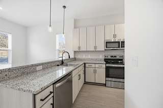 A kitchen with granite countertops and stainless steel appliances.