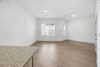 A room with a window showing a building outside.