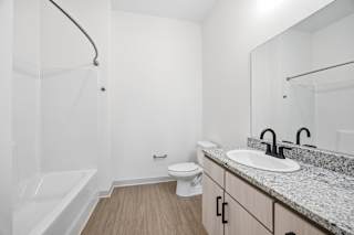 A white bathroom with a sink, toilet, and bathtub.