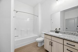 A white bathroom with a toilet, sink, and bathtub.