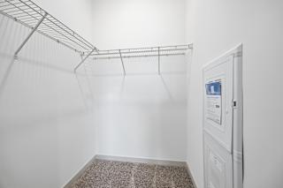 A white closet with a metal rack and a white door with a screen.