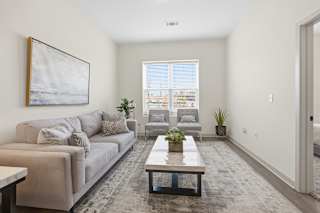A living room with a couch, a coffee table, and a painting on the wall.