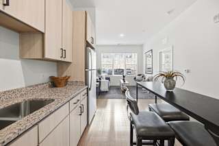 A kitchen with a counter and chairs.